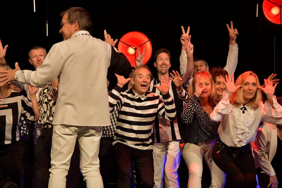 Groupe de choristes sur scène avec éclairage rouge spectaculaire