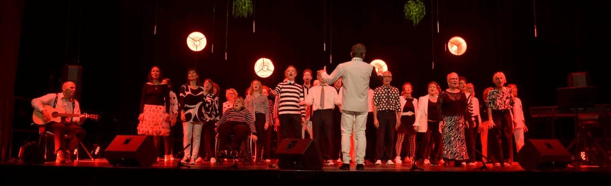 Ensemble complet de La Cecilia sur scène sous éclairage rouge
