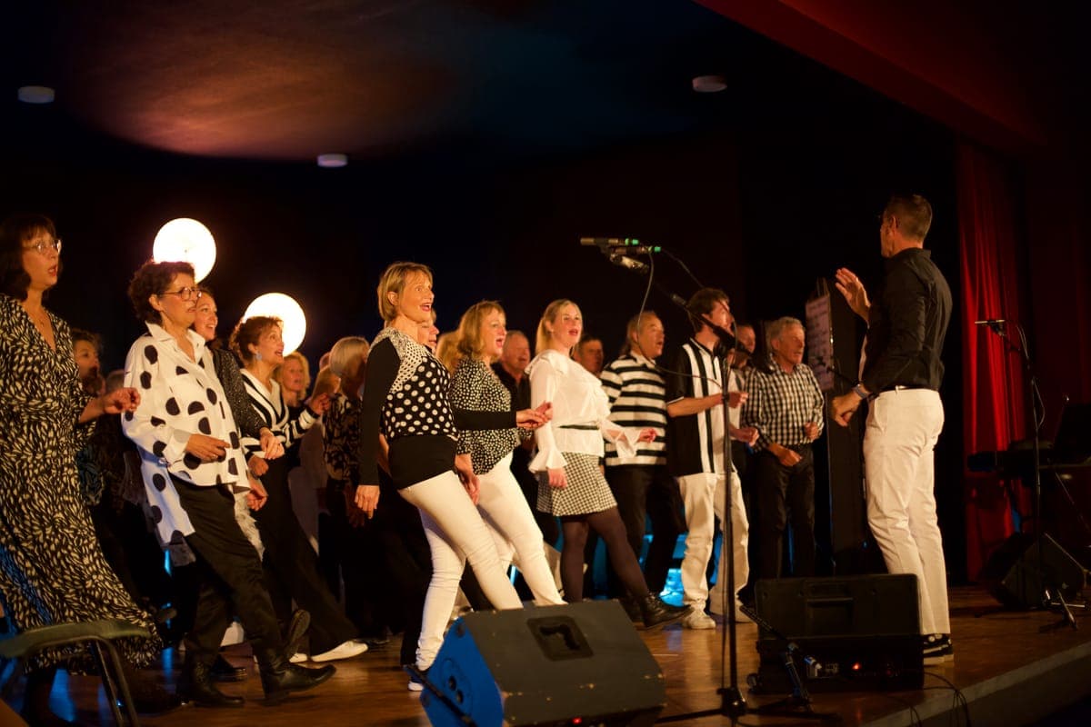 Groupe complet choristes tenue noire blanche scène