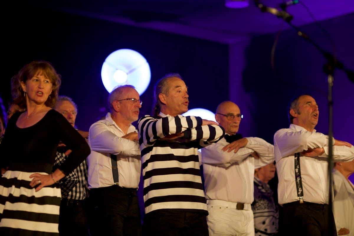 Groupe de choristes chantant en scène avec éclairage violet
